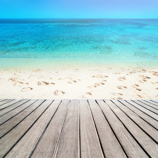 Песчаный пляж на Солнечный день с деревянной дорожке - синее море и bl — стоковое фото